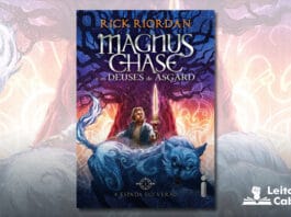 Capa do livro. No centro da capa, um rapaz loiro de camiseta branca e casaco azul. Uma espada dourada e brilhante flutua de pé sobre a mão dele. Atrás dele, uma árvore grossa com inumeros galhos secos, com uma luz roxa sobre a árvore. Frente ao rapaz, um enorme lobo azul e feroz. No fundo, no topo um céu noturno azul e estrelado, abaixo desenhos de aspecto nórdico antigo, brilhando com fundo de cores em degradê amarelo, laranja, roxo e vermelho. Em primeiro plano, no topo, o nome do autor, e abaixo o título: Magnus Chase, e os Deuses de Asgard.